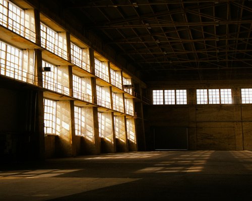 Light shining through broken windows of warehouse
